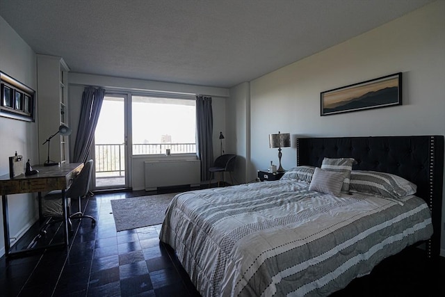 bedroom with access to exterior and a textured ceiling