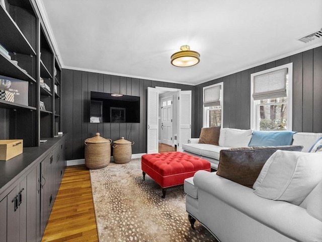 living room featuring crown molding and light wood-type flooring