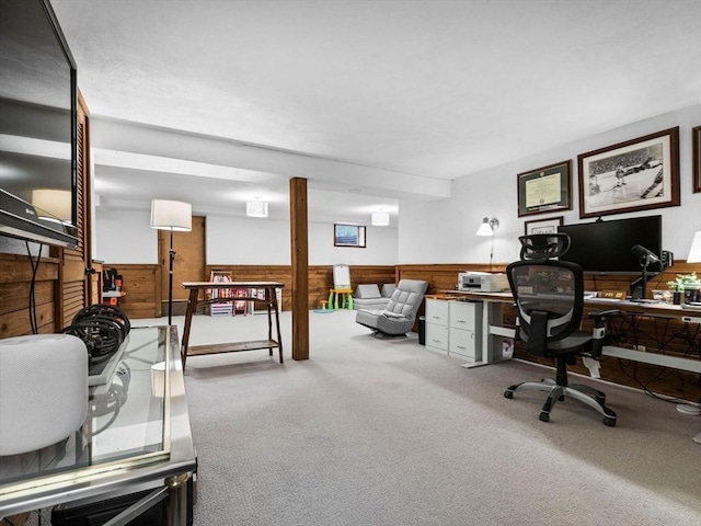 carpeted home office featuring wooden walls