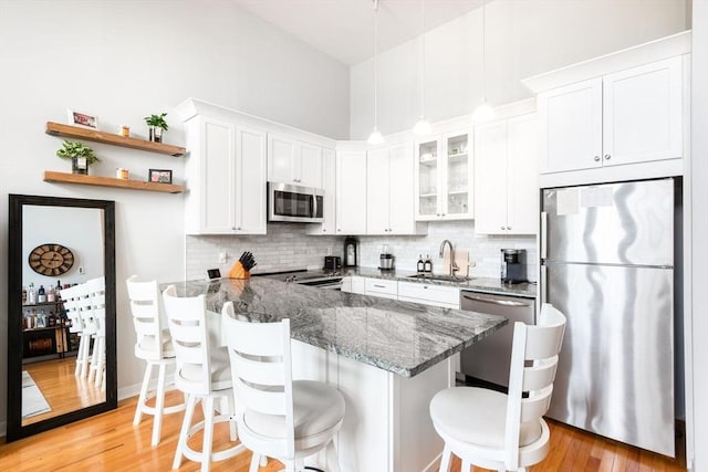 743 E 4th Unit 204, Boston, MA 02127 - kitchen featuring stainless steel appliances, a sink, white cabinetry, a breakfast bar, and a peninsula