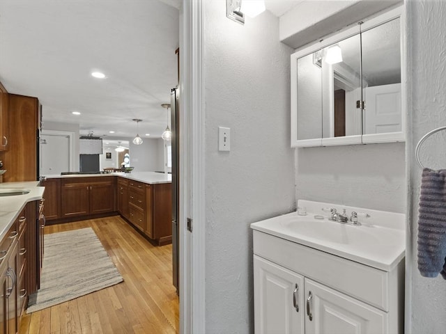 886 Methuen St, Dracut, MA 01826 - bathroom featuring a textured wall, wood finished floors, vanity, and recessed lighting