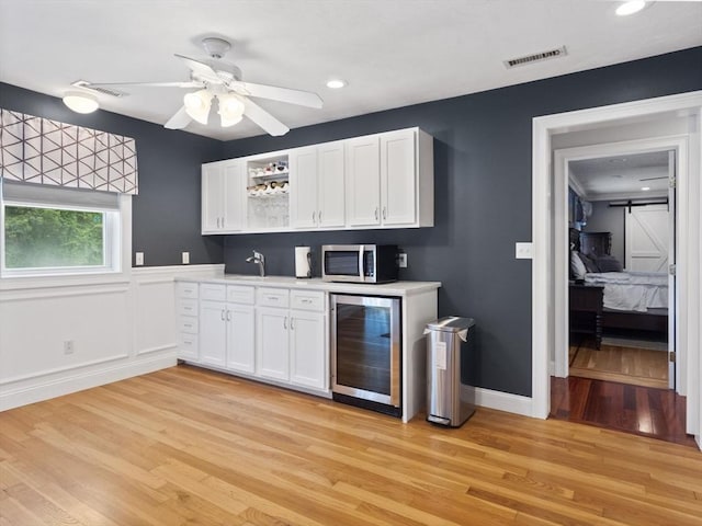 886 Methuen St, Dracut, MA 01826 - kitchen with wine cooler, stainless steel microwave, open shelves, light countertops, and recessed lighting