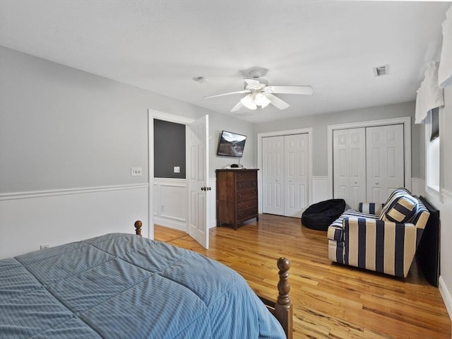 886 Methuen St, Dracut, MA 01826 - bedroom with two closets, light wood finished floors, a wainscoted wall, and a ceiling fan