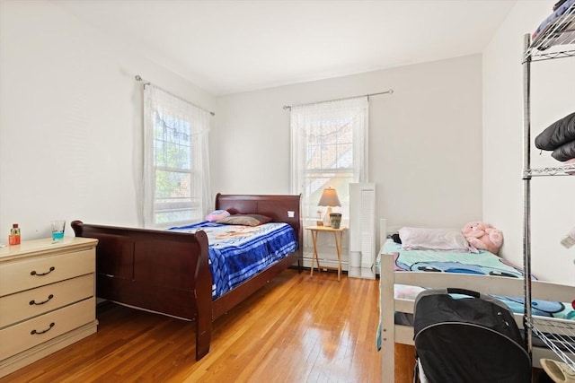 23 Gordon St, Boston, MA 02134 - bedroom featuring multiple windows, light wood-type flooring, and a baseboard radiator