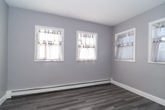 unfurnished room with dark wood-type flooring and a baseboard heating unit