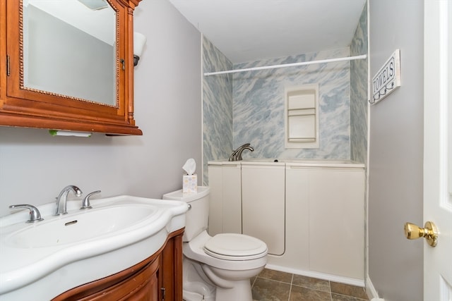 bathroom with tile patterned flooring, vanity, and toilet