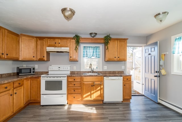 kitchen with a wealth of natural light, sink, a baseboard radiator, and white appliances