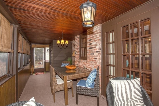 unfurnished sunroom featuring an inviting chandelier and wooden ceiling