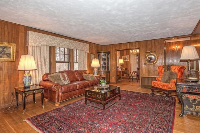 living room featuring wood walls, radiator, a textured ceiling, and hardwood / wood-style floors