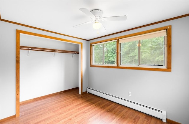 24 Horton Rd, Orange, MA 01364 - unfurnished bedroom featuring a baseboard heating unit, multiple windows, crown molding, a closet, and light wood-style floors