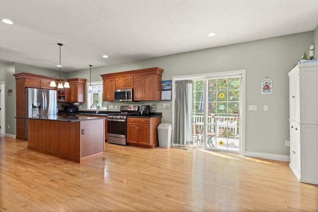 1 Windsor Rd, Shirley, MA 01464 - kitchen with stainless steel appliances, dark countertops, light wood-style flooring, a center island, and healthy amount of natural light
