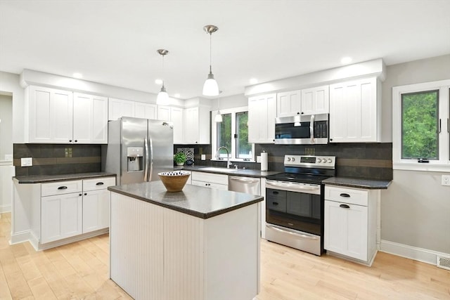 3 Pine Knl, Southwick, MA 01077 - kitchen with appliances with stainless steel finishes, dark countertops, a sink, light wood-style floors, and decorative backsplash