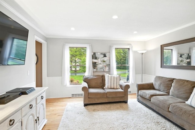 3 Pine Knl, Southwick, MA 01077 - living area featuring wainscoting, light wood finished floors, plenty of natural light, a baseboard heating unit, and ornamental molding