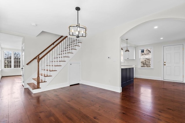6 Parker Ave, Cohasset, MA 02025 - entrance foyer with arched walkways, dark wood-style floors, a chandelier, stairs, and baseboards