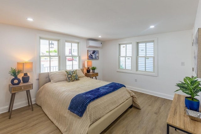 247 Pitman St, Fall River, MA 02723 - bedroom with an AC wall unit, light wood finished floors, baseboards, and recessed lighting