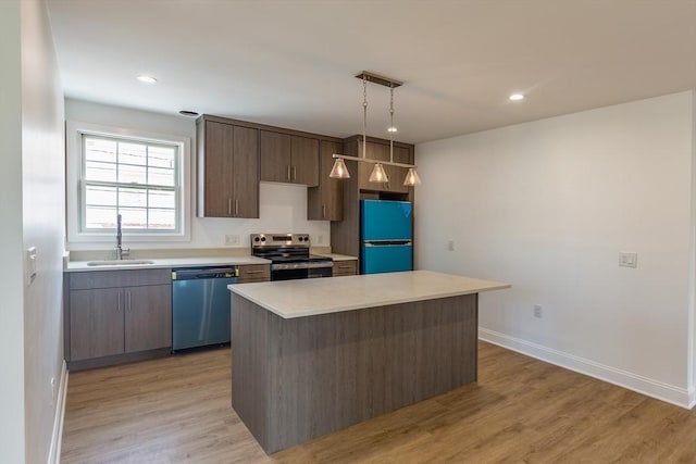 247 Pitman St, Fall River, MA 02723 - kitchen with appliances with stainless steel finishes, a sink, baseboards, light countertops, and light wood-style flooring