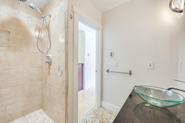 bathroom with tile patterned floors, vanity, and tiled shower