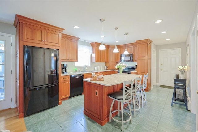 kitchen with a sink, a center island, black appliances, and recessed lighting