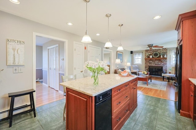 kitchen with a ceiling fan, a fireplace, dark tile patterned flooring, freestanding refrigerator, and open floor plan