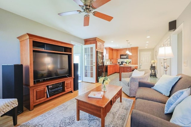 living area featuring ceiling fan and light wood finished floors