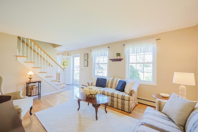 living area with light wood-style floors, a baseboard radiator, and stairway