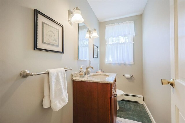 half bath with baseboards, a baseboard radiator, toilet, and vanity