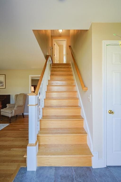 stairs with baseboards and wood finished floors
