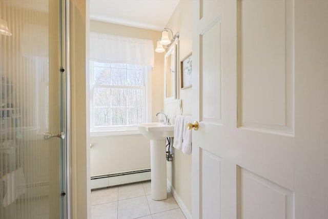 bathroom with an enclosed shower, tile patterned floors, baseboards, and a baseboard heating unit