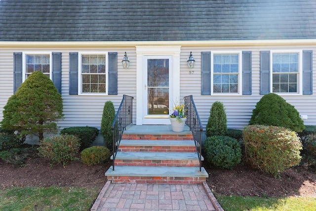 entrance to property featuring a shingled roof