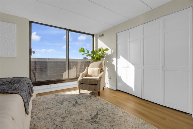 sitting room with floor to ceiling windows and wood-type flooring