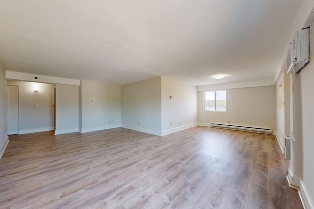 47 Mystic St Unit 4E, Arlington, MA 02474 - empty room featuring baseboard heating, light wood-style floors, and baseboards