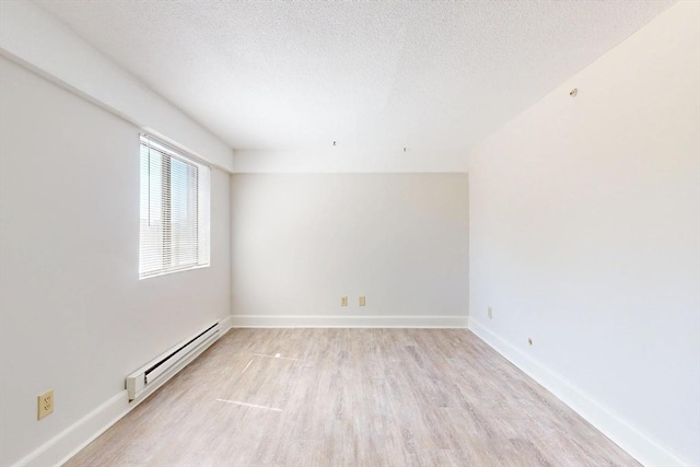 47 Mystic St Unit 4E, Arlington, MA 02474 - empty room featuring a baseboard radiator, light wood-type flooring, a textured ceiling, and baseboards
