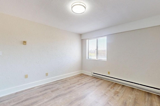 47 Mystic St Unit 4E, Arlington, MA 02474 - unfurnished room with a baseboard heating unit, light wood-style floors, a textured wall, and baseboards