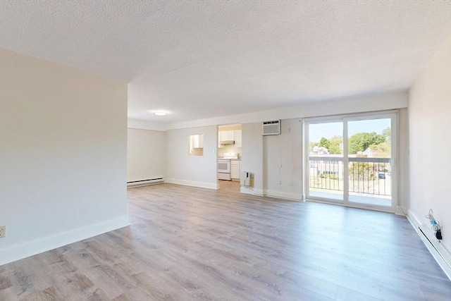 47 Mystic St Unit 4E, Arlington, MA 02474 - unfurnished living room with baseboard heating, a textured ceiling, light wood-type flooring, baseboards, and a wall mounted air conditioner