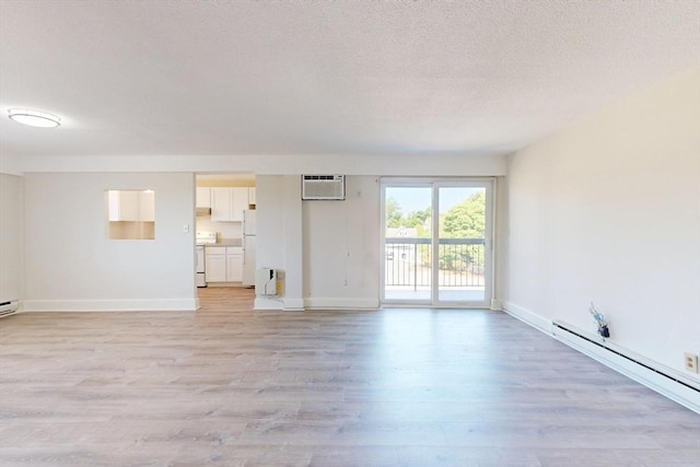 47 Mystic St Unit 4E, Arlington, MA 02474 - spare room with a baseboard heating unit, light wood-style floors, a wall mounted air conditioner, and baseboards