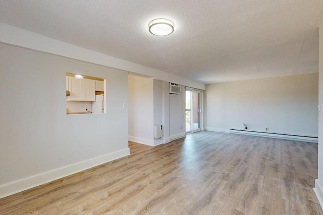 47 Mystic St Unit 4E, Arlington, MA 02474 - empty room with an AC wall unit, light wood-type flooring, baseboards, and a baseboard heating unit