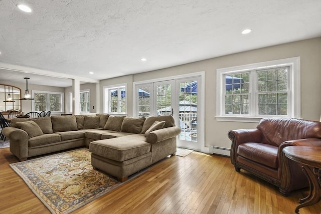 living area featuring a baseboard heating unit, hardwood / wood-style floors, and recessed lighting