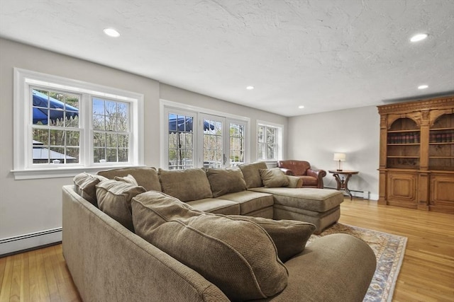 living room with light wood-type flooring, recessed lighting, and a baseboard radiator