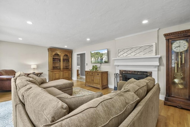 living room with baseboards, a brick fireplace, and recessed lighting