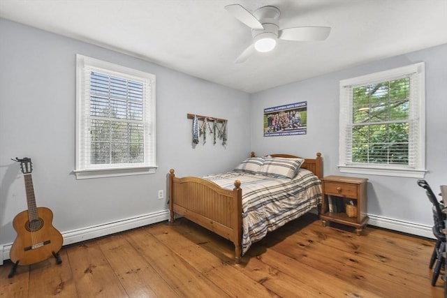 bedroom with a baseboard radiator, baseboards, ceiling fan, and light wood-type flooring