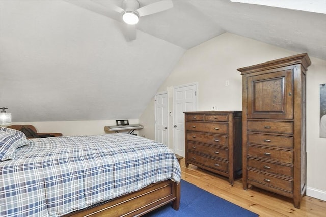 bedroom featuring ceiling fan, lofted ceiling, and light wood-style floors