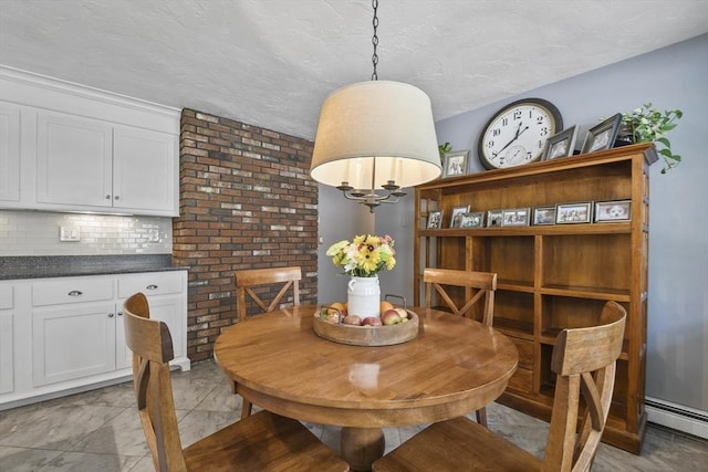 dining space with a baseboard heating unit and a textured ceiling