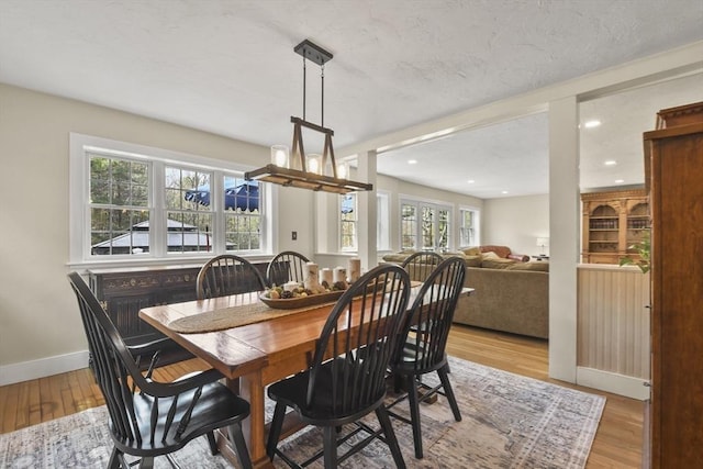 dining room with baseboards, light wood finished floors, and recessed lighting