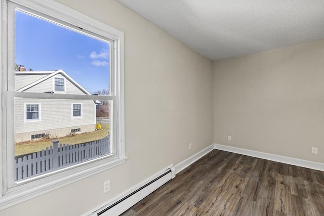 empty room featuring dark hardwood / wood-style flooring and a baseboard heating unit