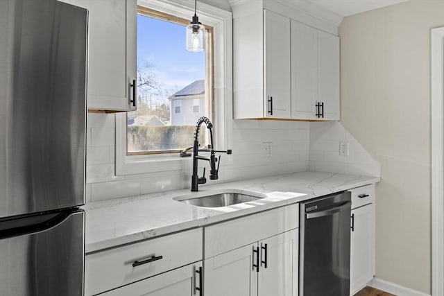 kitchen with white cabinets, appliances with stainless steel finishes, decorative light fixtures, and sink