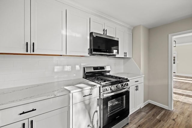 kitchen with white cabinetry, dark wood-type flooring, light stone countertops, and appliances with stainless steel finishes