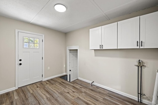 laundry area featuring cabinets and light hardwood / wood-style flooring