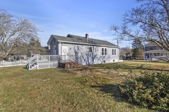 back of property featuring a lawn and a wooden deck