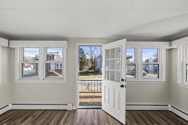 entryway with wood-type flooring and a baseboard heating unit