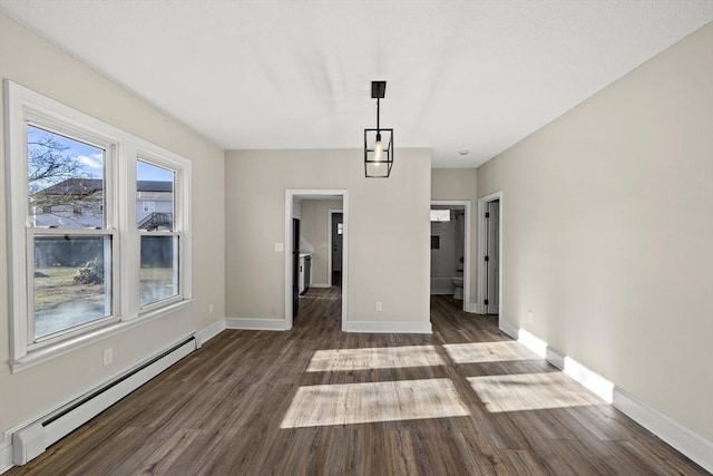 unfurnished dining area featuring a chandelier, dark wood-type flooring, and a baseboard heating unit